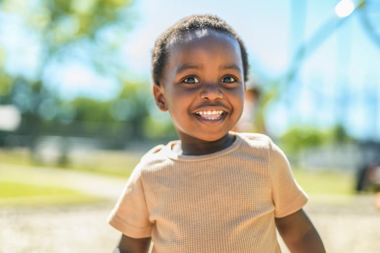 A happy young African child on a playground in summer