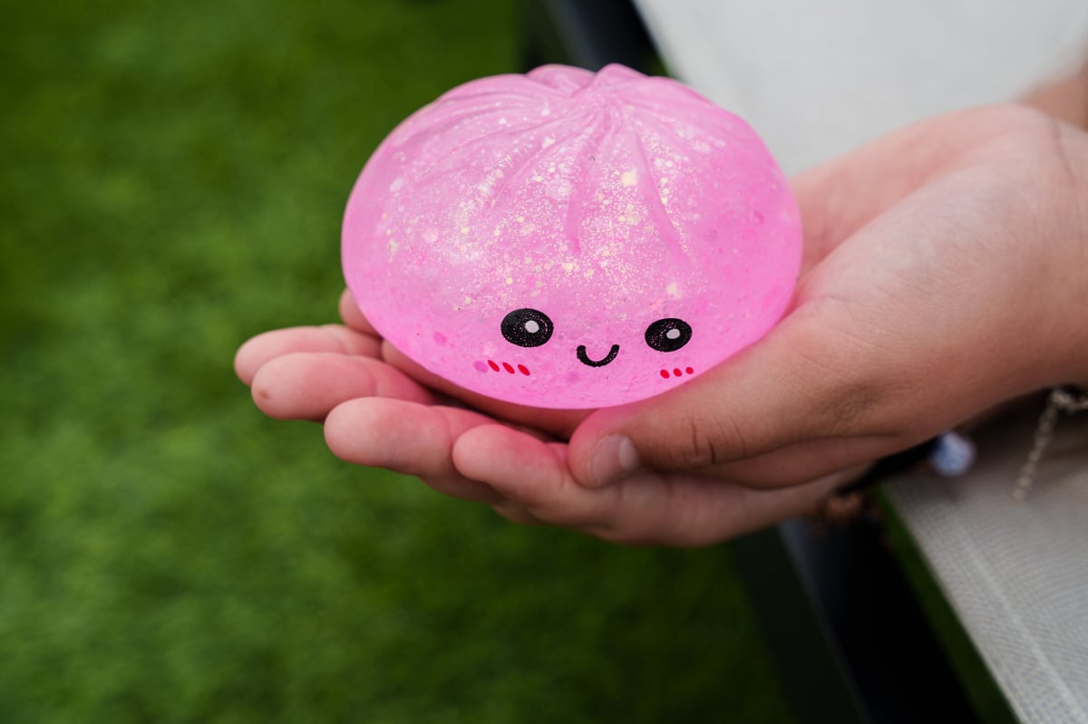 Child holding a pink glitter dumpling squishy toy