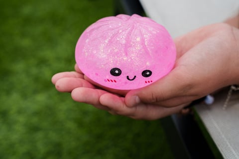 Child holding a pink glitter dumpling squishy toy