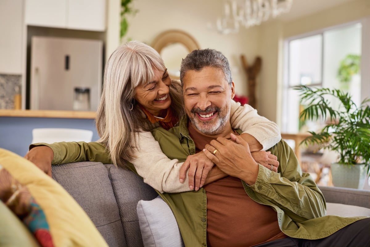 Mature couple relaxing together at home after paying down their mortgage