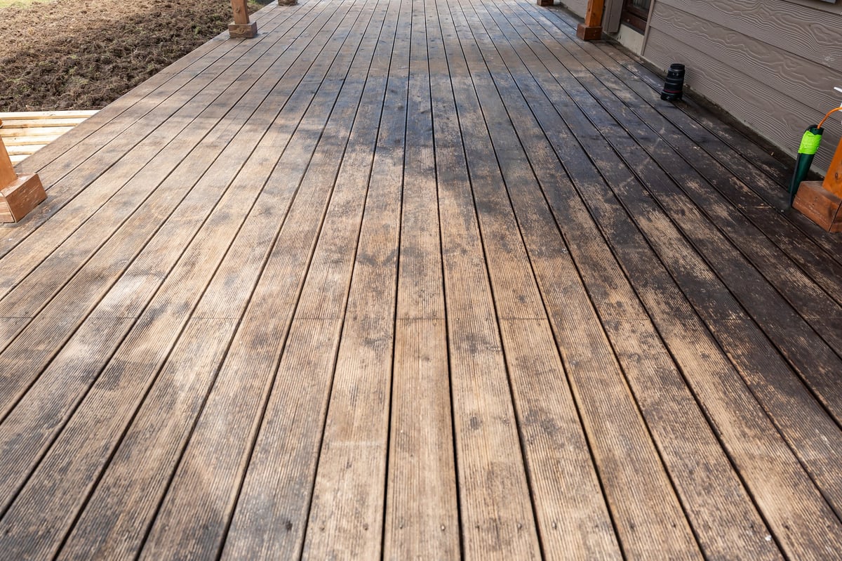 Gray weathered deck boards showing signs of age and neglect, before restoration