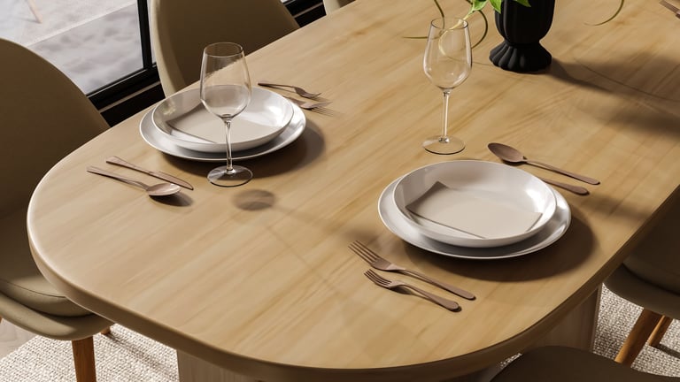 Close up of a modern wooden dining table featuring elegant tableware, wine glasses and cutlery in warm natural lighting