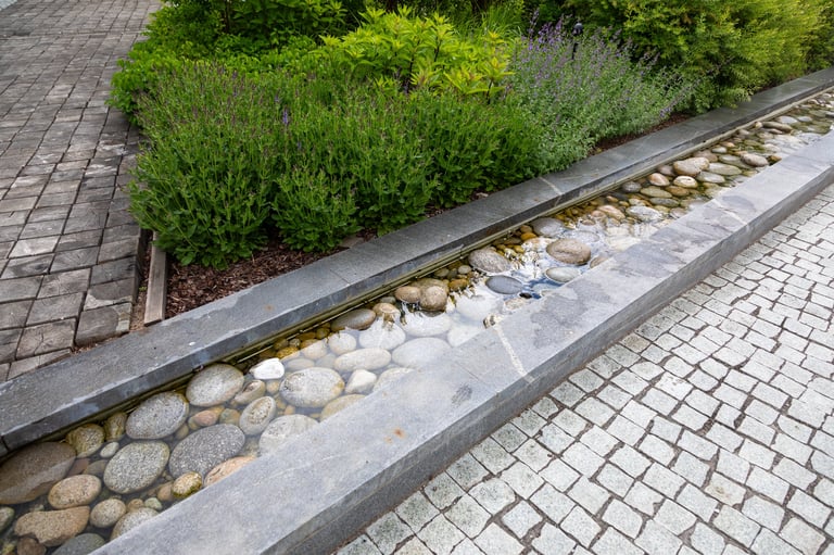 Contemporary garden path with concrete edging, pebble drainage strip and cobblestone paving