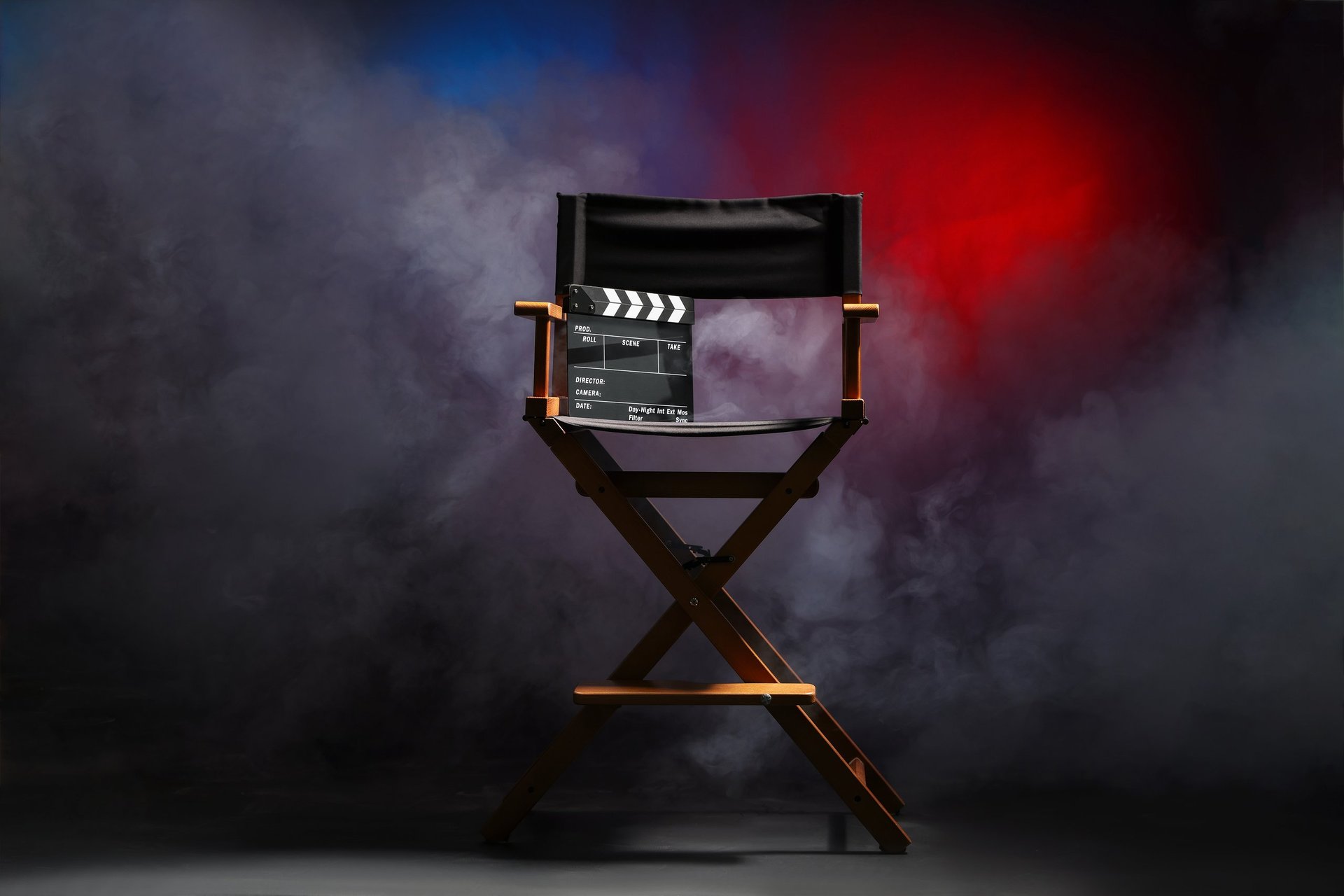 Chaise de réalisateur et clap sur fond sombre avec fumée et lumières