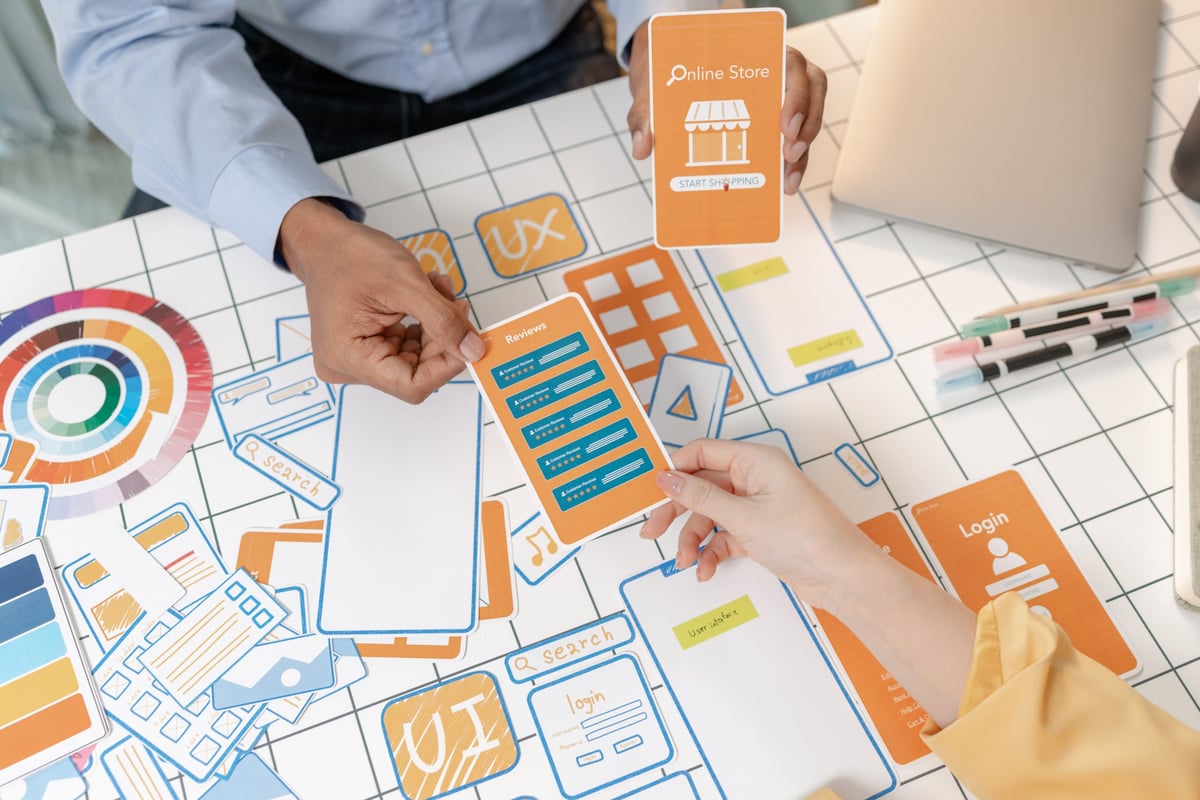 UX designers collaborating on website redesign wireframes and mobile app mockups