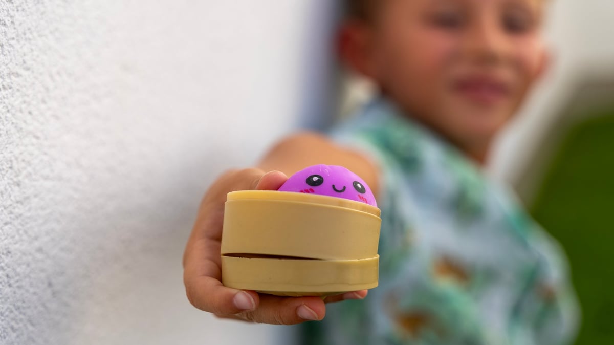 A cute dumpling squishy toy held in a child's hand