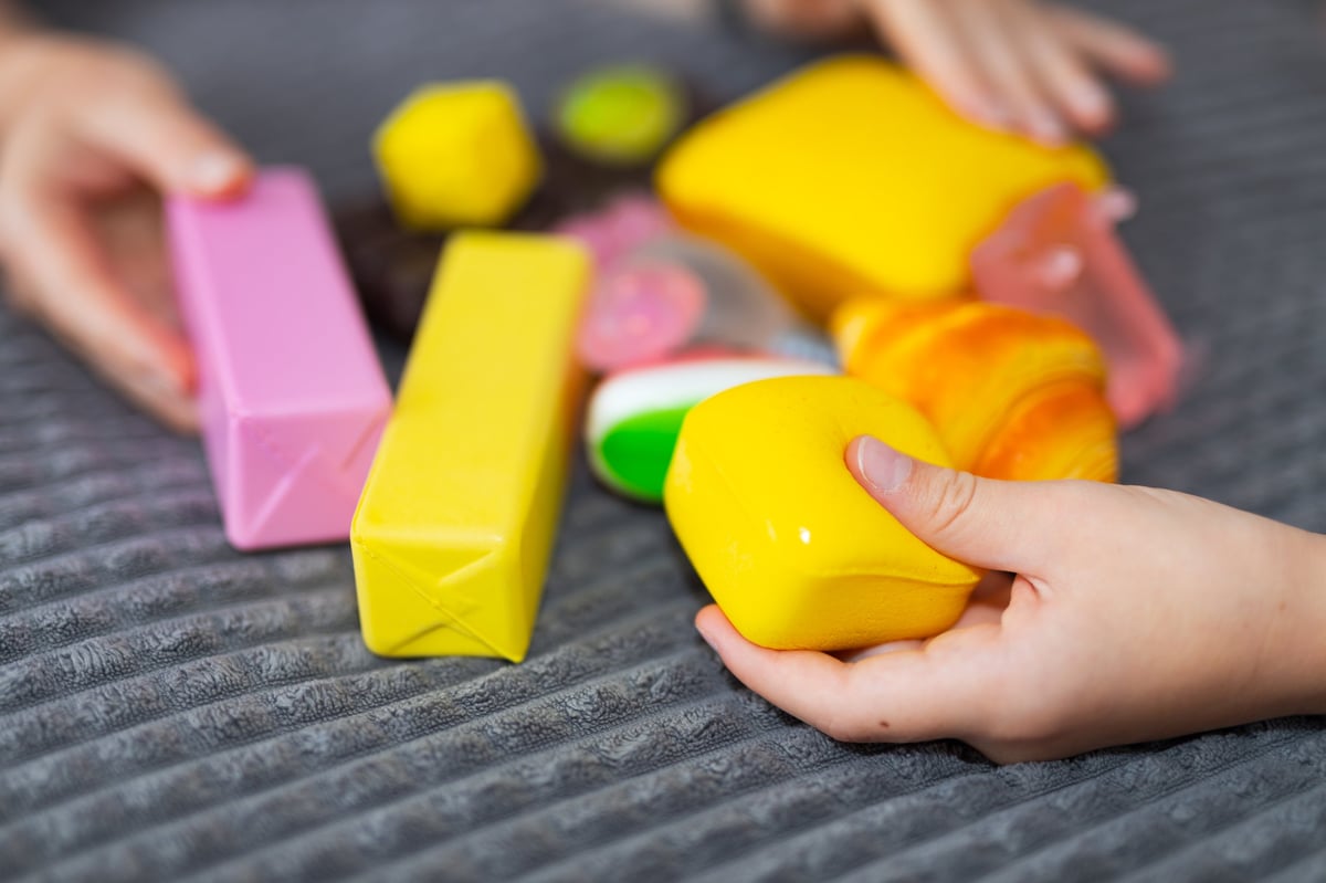 Children's hands holding colorful squishy sensory toys