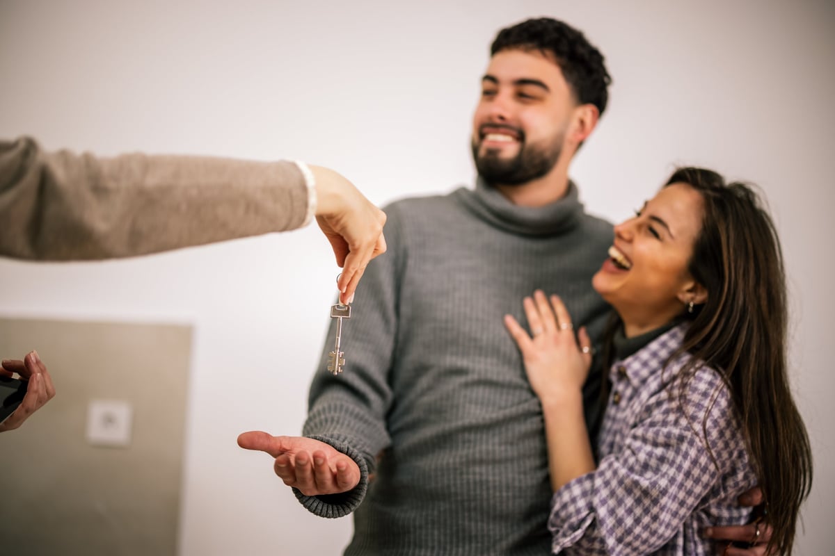 Couple receiving the keys to their first home after an FHA loan closing