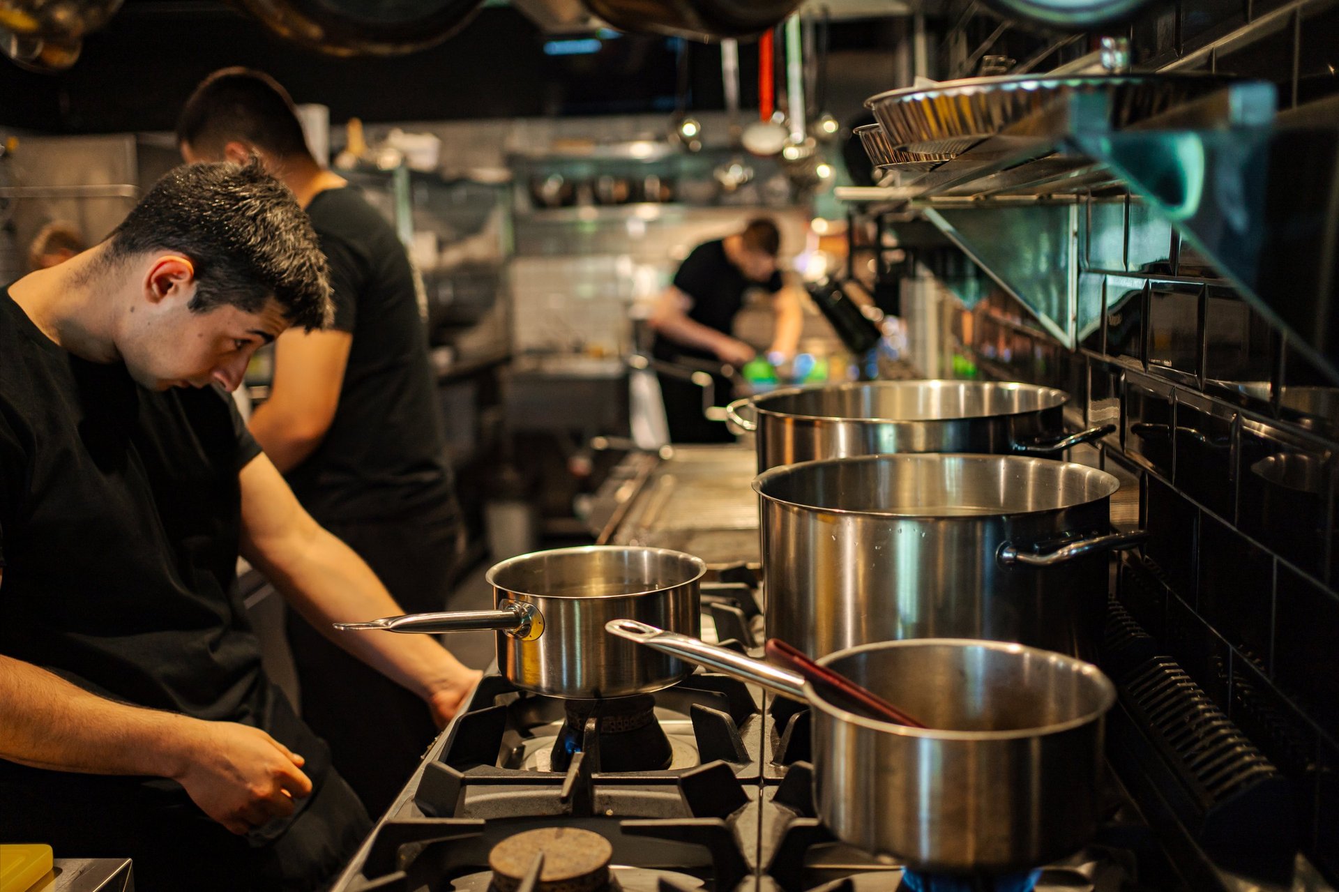Restaurant chefs preparing food on the stoves in a professional kitchen during service