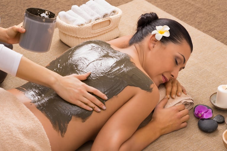 Woman receiving a luxurious mud and clay body therapy at a spa