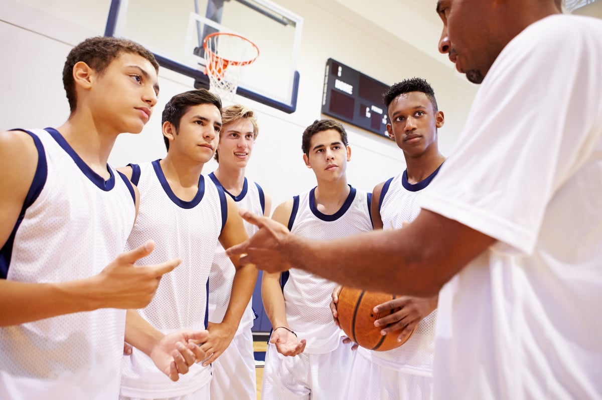 Lighthouse Athletics coach talking with student-athletes during a team huddle