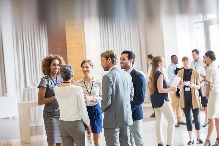Diverse professionals networking and chatting at a career fair in a bright modern space