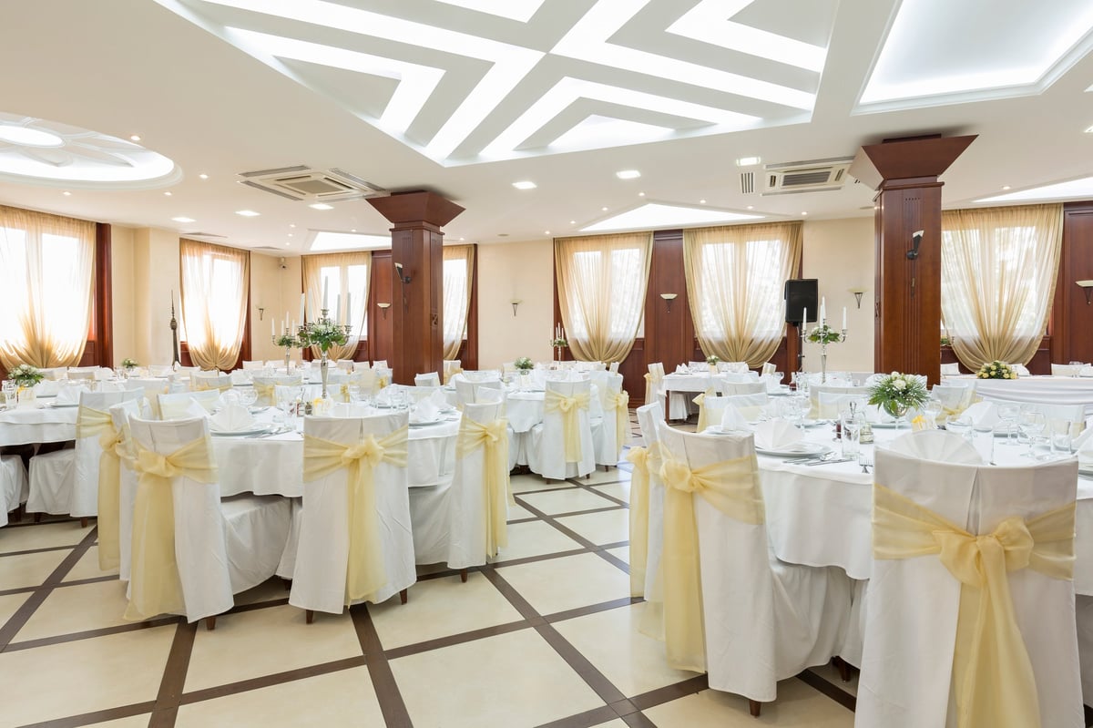 Wedding hall set for fine dining with tables and chairs