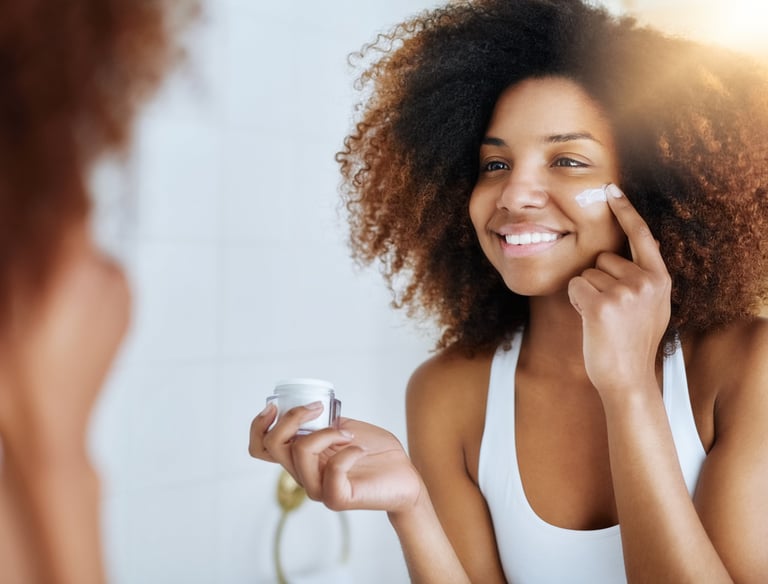 A woman applying moisturiser to her face in front of the mirror as part of her daily routine