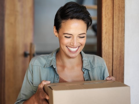 Cliente recibiendo paquete de mensajería en la puerta de su casa