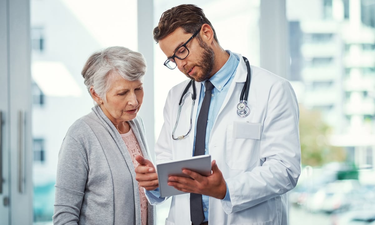 Doctor consulting with patient using a digital tablet
