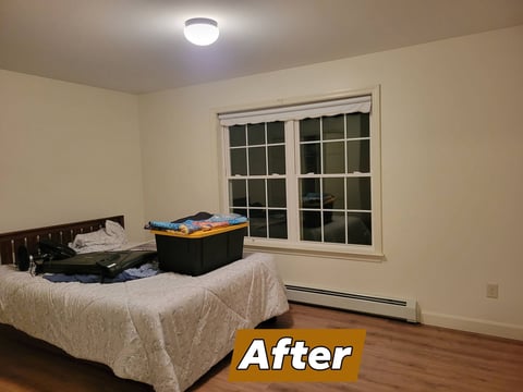 After: Bedroom interior with bed, storage bin, window, ceiling light, and hardwood floor