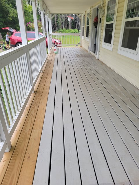 Before: Long porch with gray and brown composite decking, white railings, and cream-colored house exterior with windows and doors
