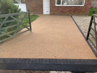 Tan resin bound driveway with wooden gates