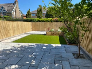 Modern landscaping with dark paving and lawn