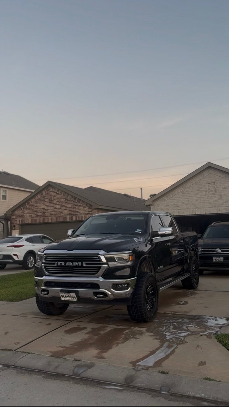 Black RAM 1500 pickup truck with mirror-like finish parked in driveway at dusk — KJAJ Details finished detail