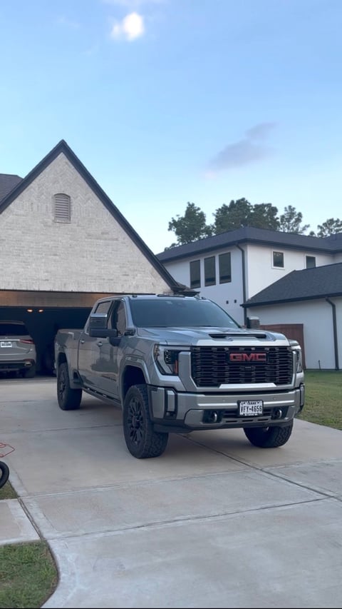 KJAJ Details finished detail — silver GMC Sierra pickup with mirror-like finish parked in a residential driveway