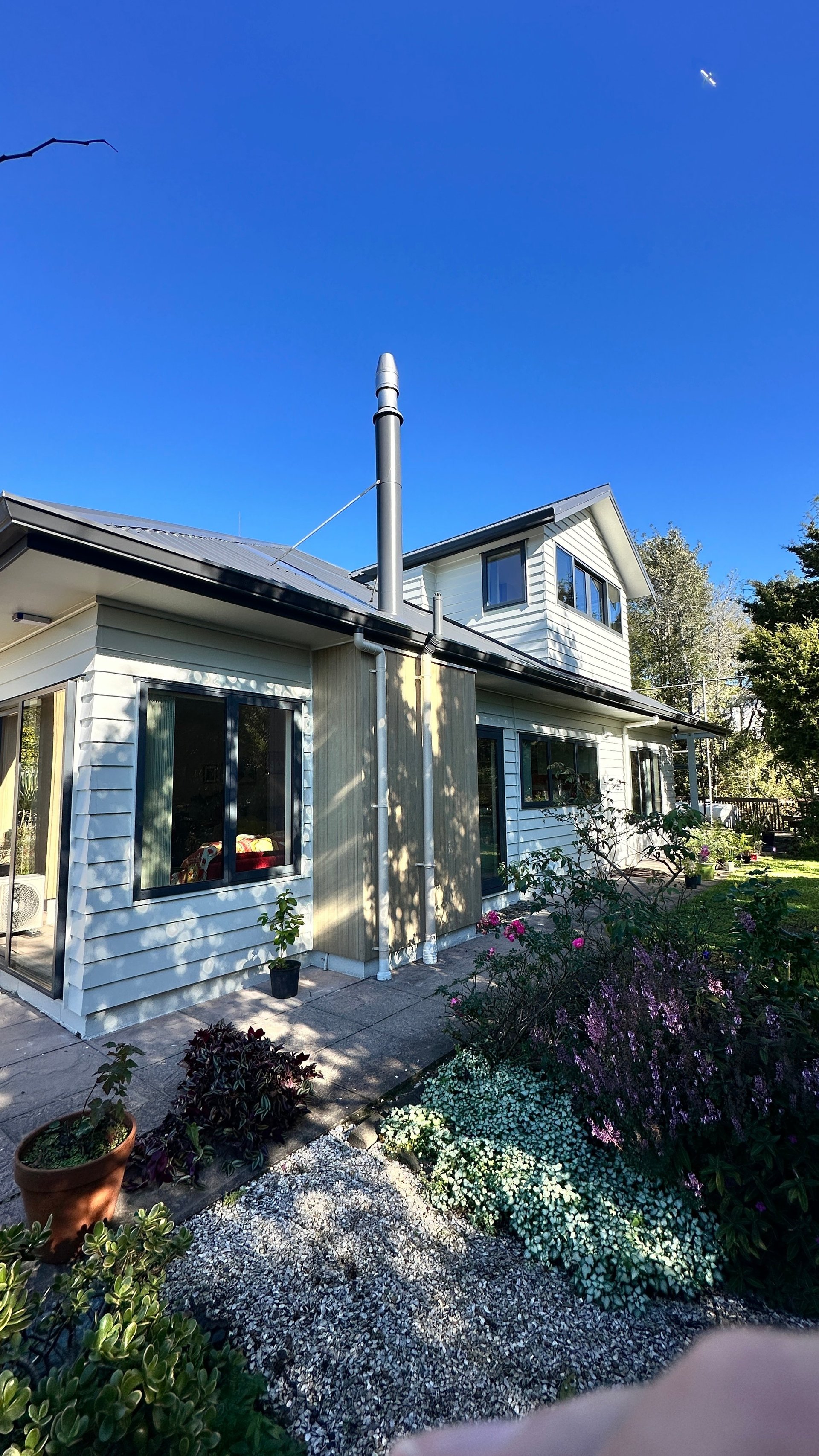 Completed North Shore home exterior with new cladding and landscaping at dusk
