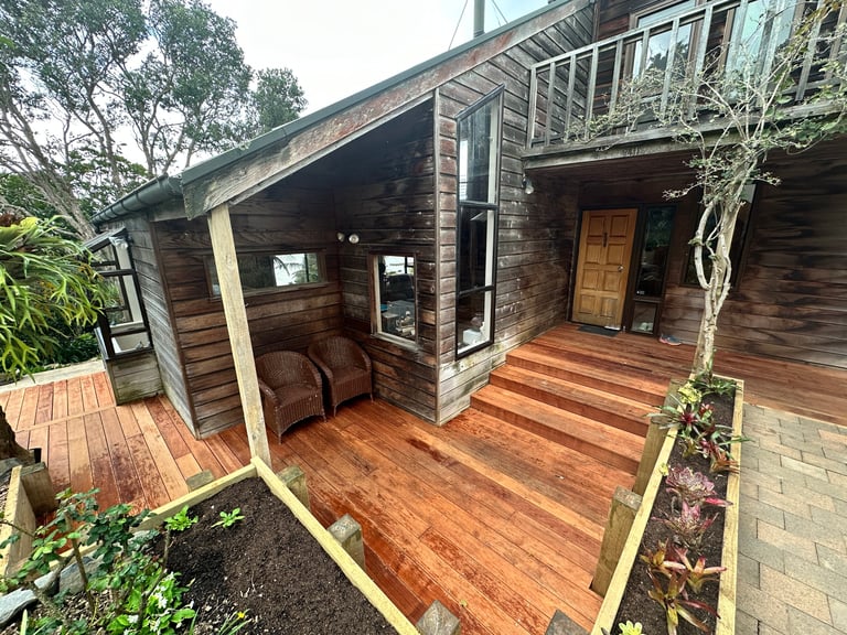 Dark timber home with a deck extending into an outdoor living area