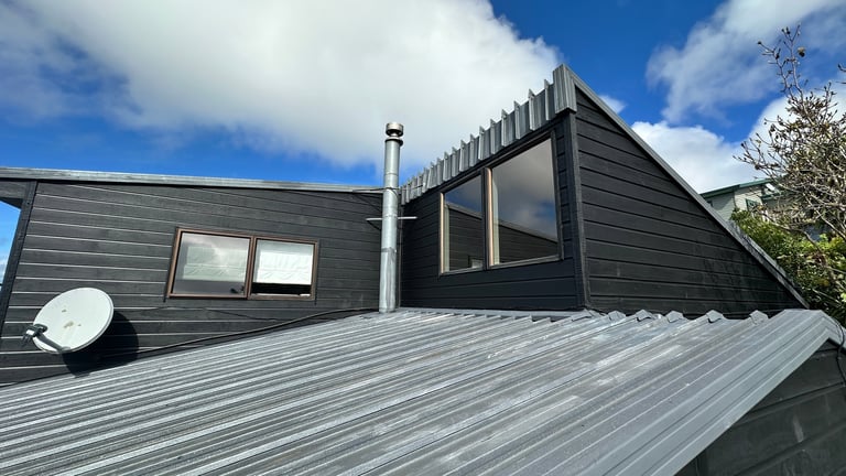 Reclad North Shore home with new weatherboards, metal roof and large windows