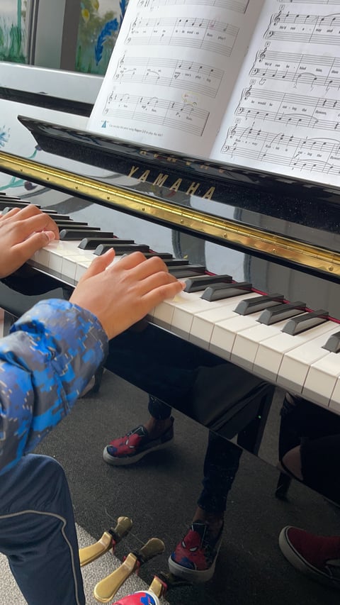 Child playing a Yamaha piano with sheet music