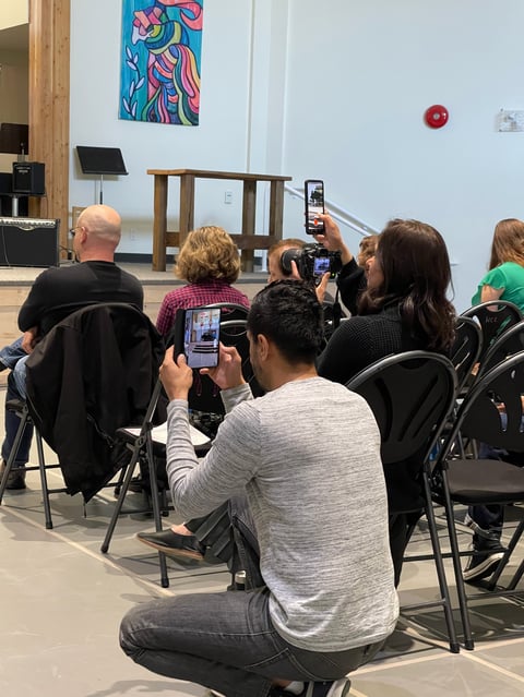 Audience members recording stage performance with smartphones