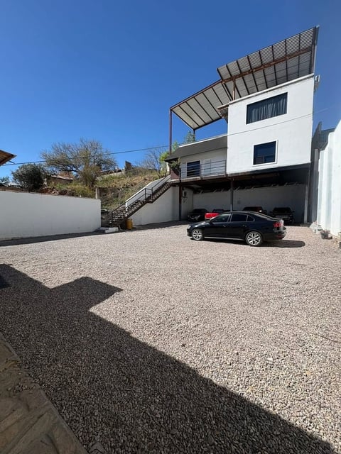 Fachada lateral con cochera techada y auto estacionado