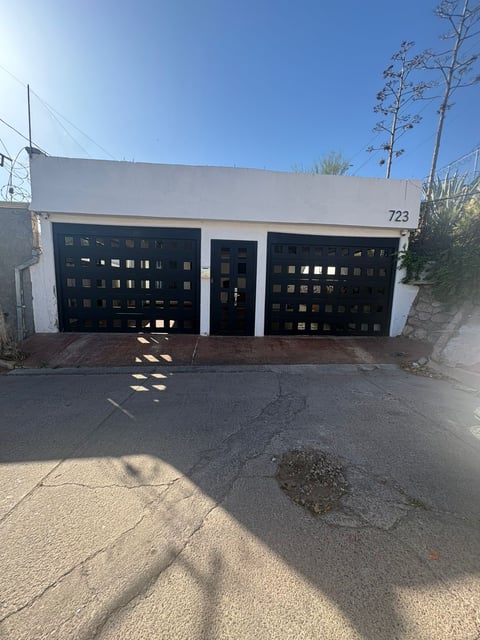 Fachada con cochera blanca de dos puertas negras modernas número 723