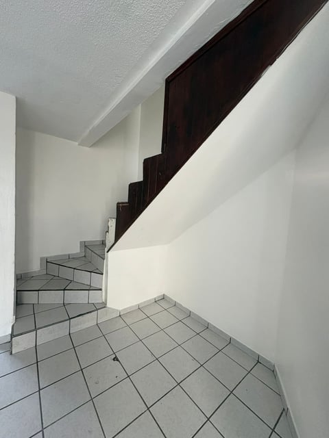 Escalera interior con barandal y escalones de madera oscura