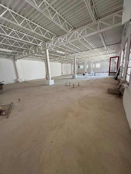 Interior del local con piso de concreto, muros blancos y estructura de vigas metálicas expuestas