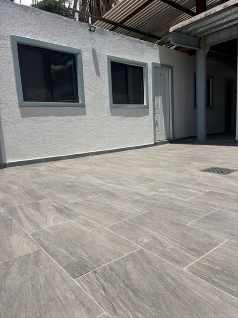 Fachada moderna blanca con patio amplio de piso tipo madera