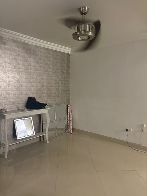 Habitación con pared de ladrillo decorativa, escritorio blanco, repisa y ventilador de techo