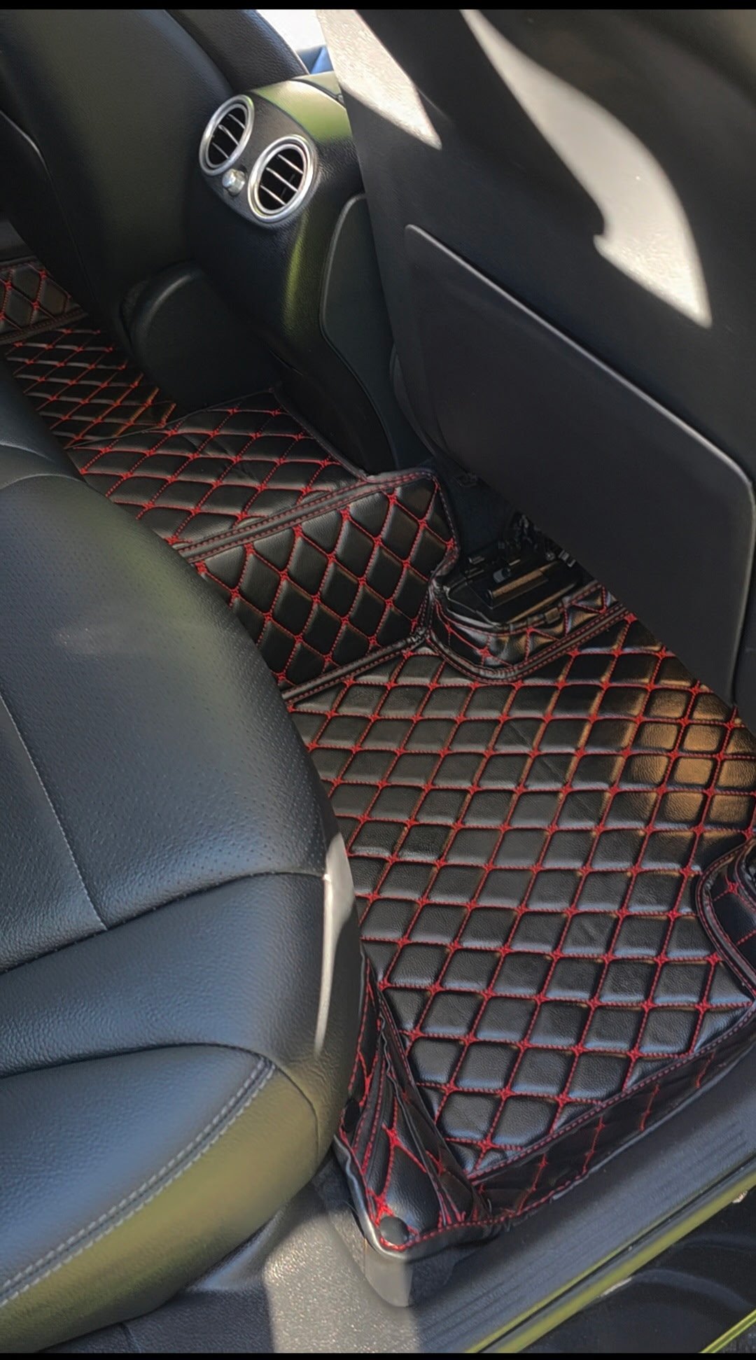 Red quilted floor mats with black leather seats and dashboard