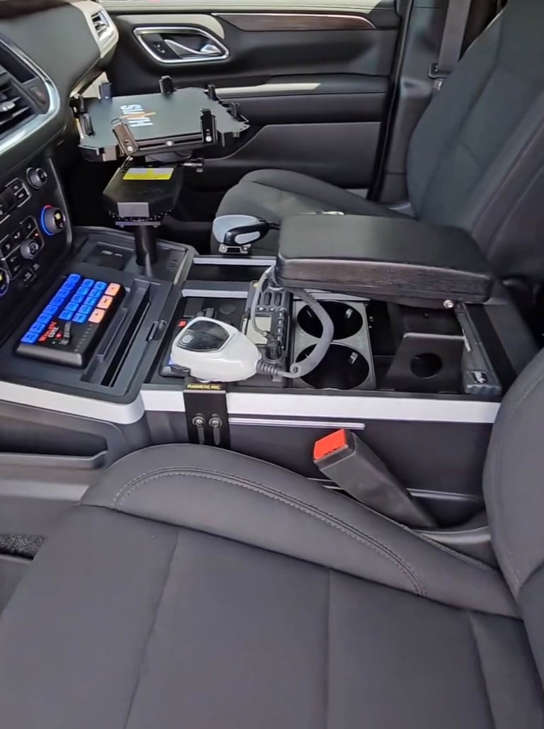 Vehicle center console open showing storage compartments with electronic devices and car accessories organized inside