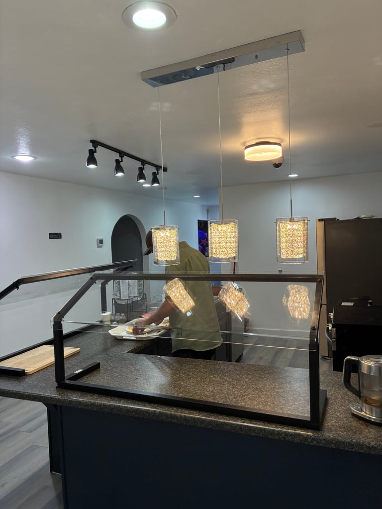 Modern counter with glass partitions and hanging pendant lights — the heart of our welcoming space