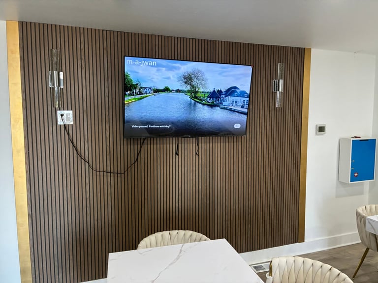 TV mounted on a beautiful fluted wood accent wall — a warm, modern detail throughout the space