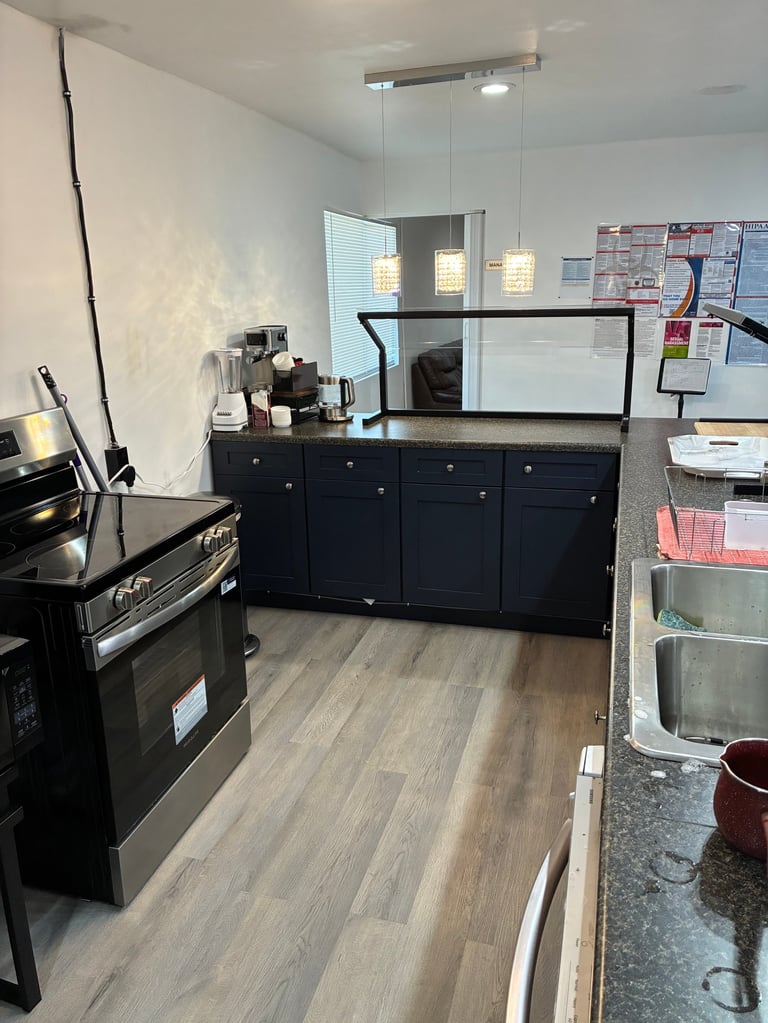 Modern kitchen with black cabinetry, stainless steel appliances, and warm pendant lighting where fresh, home-style meals are prepared