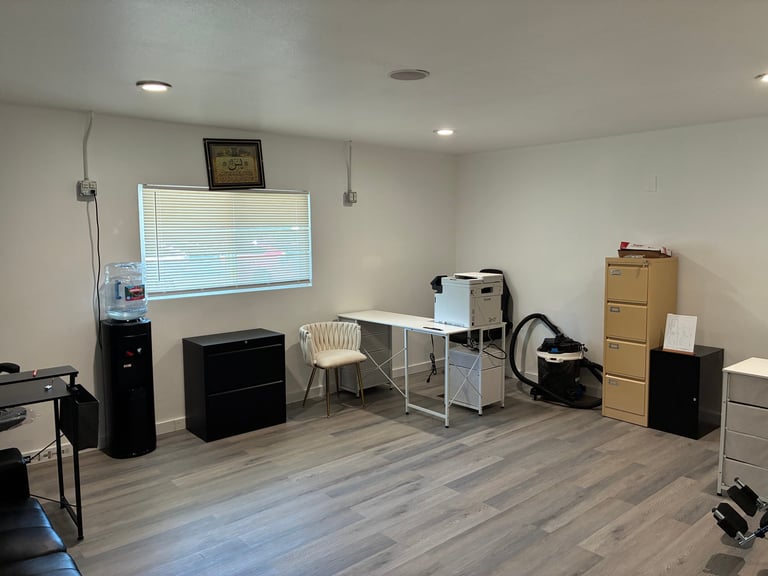 Spacious, bright room with desk, comfortable seating, and a large window letting in natural light