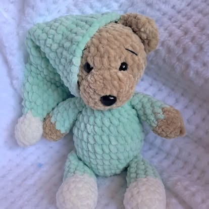 Stuffed teddy bear wearing a light mint green knitted sweater and matching beanie hat