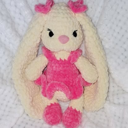 Soft cream-colored plush bunny toy with pink dress, bow, and fuzzy ears
