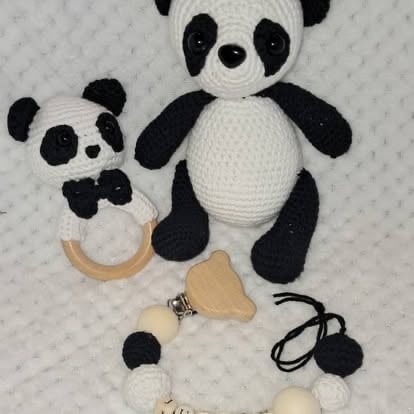 Two crocheted panda plush toys with wooden teething rings and sensory attachments on a textured white background
