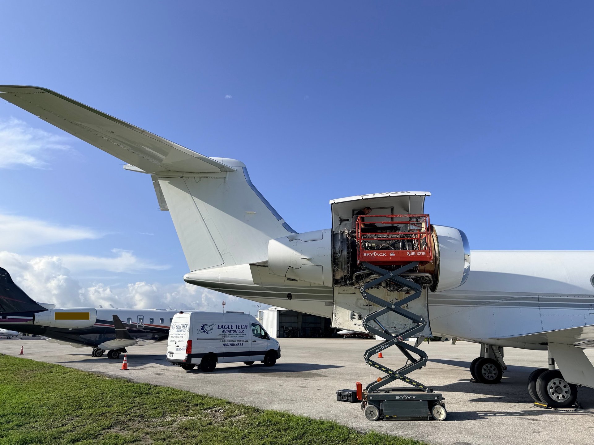 Cargo plane being loaded with freight containers using a hydraulic lift platform and ground equipment