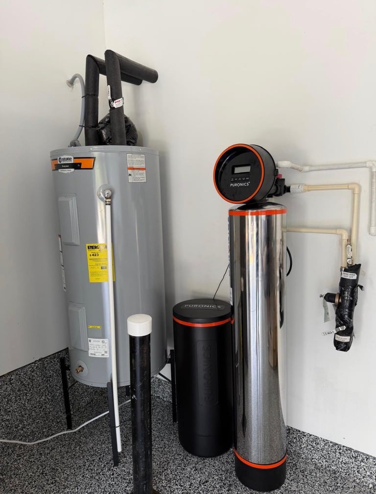 Home water treatment system with gray tank, black filtration unit, and piping mounted on wall.
