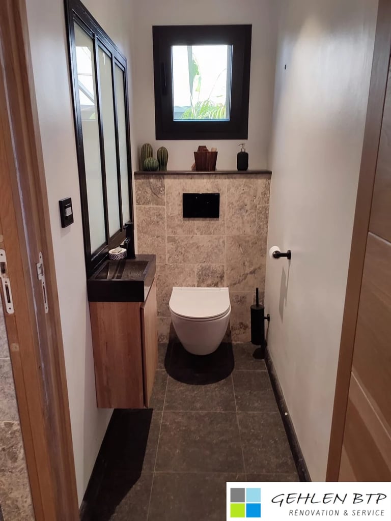 Modern small bathroom interior with white toilet, tiled walls, framed window, wall-mounted shelf with decorative cacti, and black fixtures