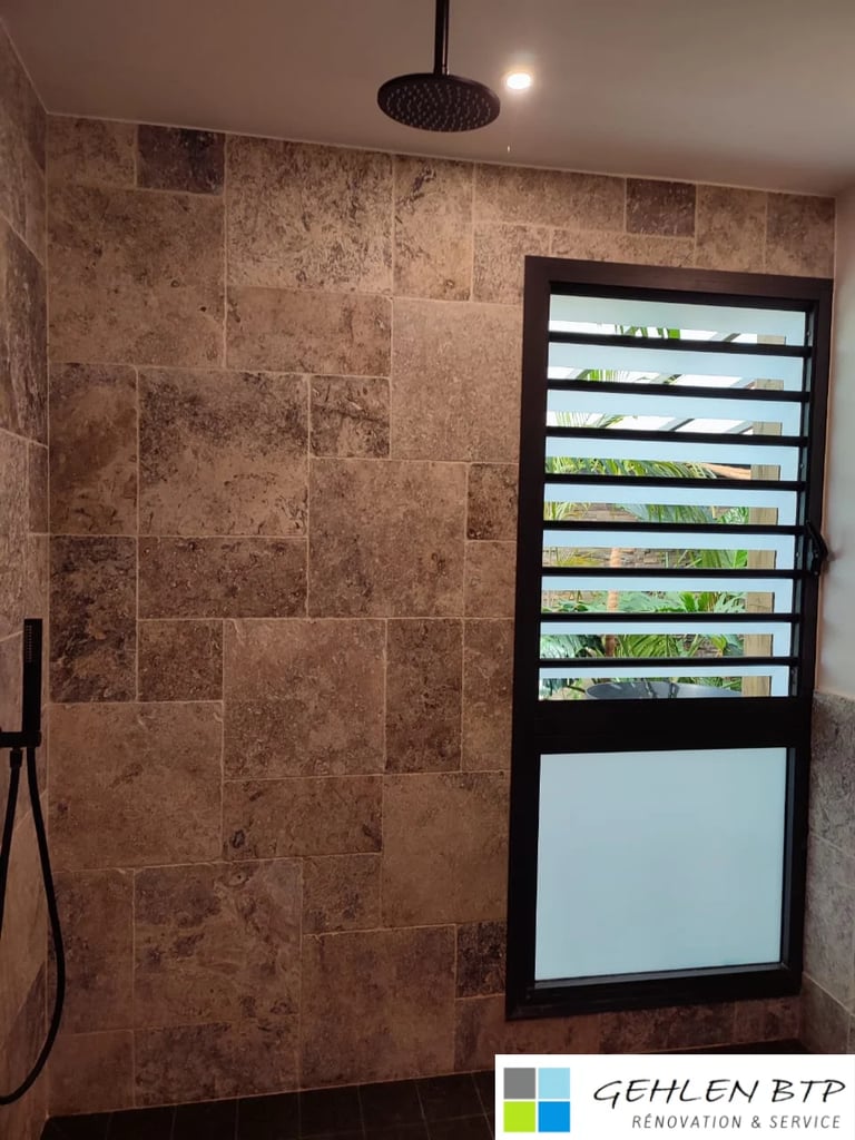 Modern bathroom shower with brown tile walls, black rainfall showerhead, louvered window, and handheld shower fixture